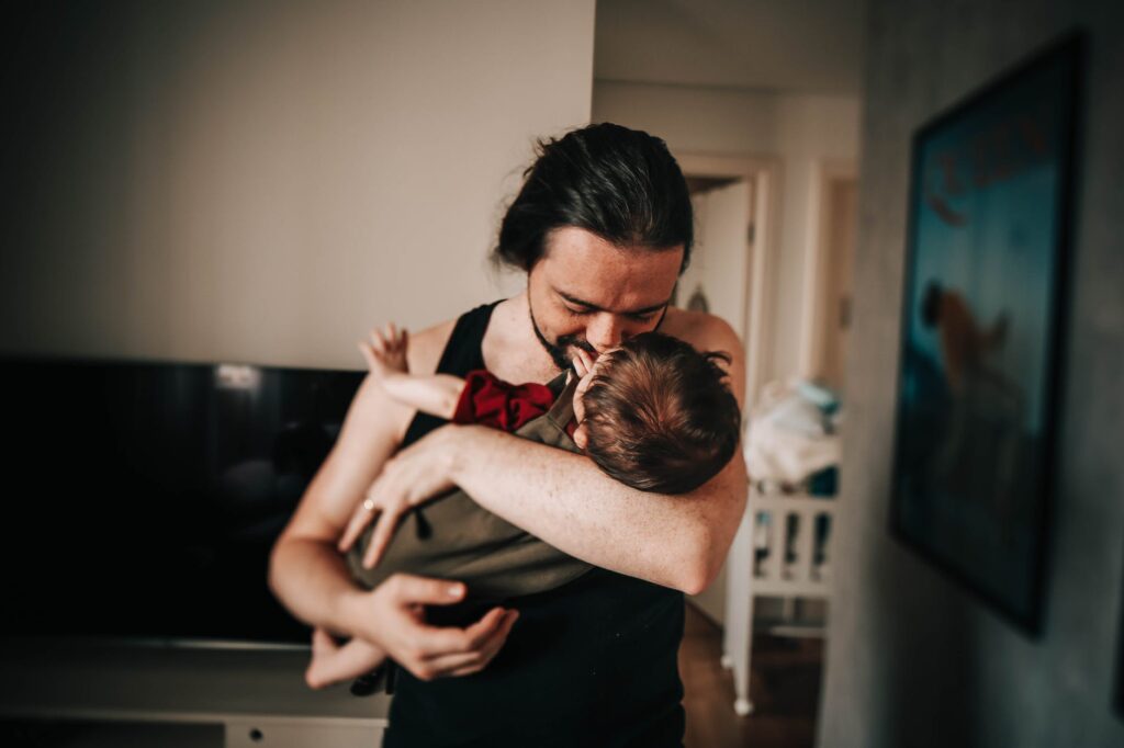 Man cuddles baby